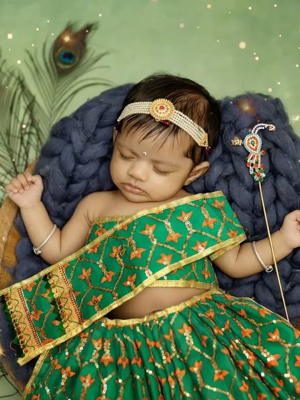 Another beautiful pose of baby Radha sleeping peacefully in her basket, holding a tiny prop.