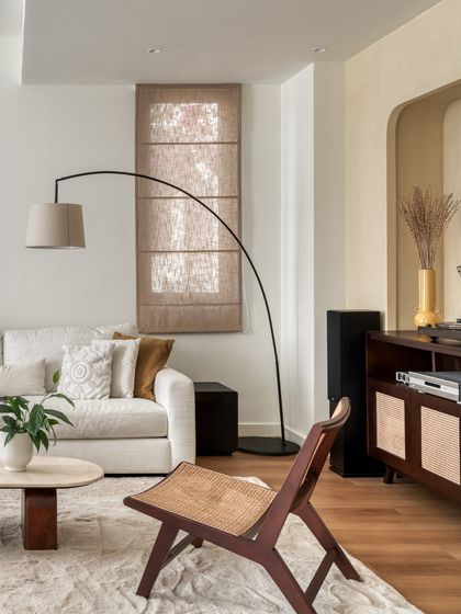 The living room is designed with soft, comfortable furniture and rounded edges, making it a safe and inviting space for children. An arched floor lamp adds a sculptural element without taking up floor space.
