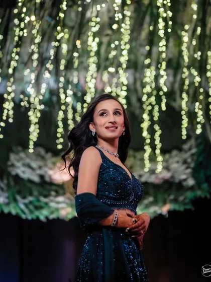 The bride looking up at the stunning floral and light installation during her Sangeet. A beautiful candid moment capturing her awe and happiness.