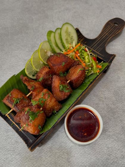 This is our 'Sizzle Pork', a dish for true pork lovers. These skewers are packed with tender, fatty cuts that are crisped up so they sizzle in their own richness, served with a spicy dipping sauce.