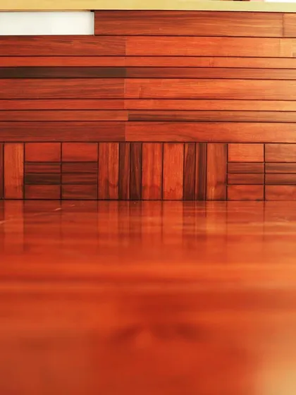 This low-angle shot emphasizes the glossy finish of the wooden floor and the texture of the wall paneling.