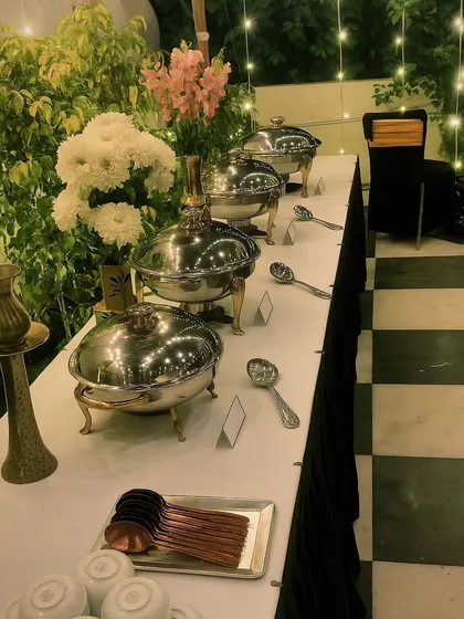 An evening buffet setup under twinkling fairy lights creates a magical atmosphere. I use a combination of warm lighting, fresh flowers, and premium serveware to make every dining experience special.
