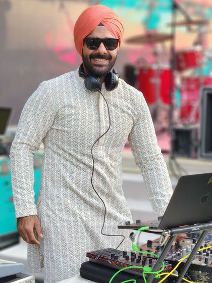 A smiling shot from behind the laptop at a sunny, outdoor wedding event.