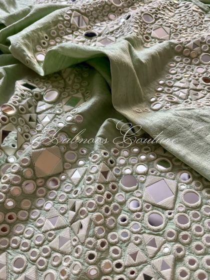 A detail shot of the palazzo's fabric, showing the dense and reflective mirrorwork.