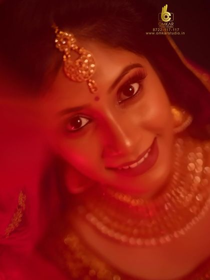 We love playing with creative lighting to add a unique feel to our bridal portraits. Here, a red light wash creates a warm, romantic, and almost cinematic glow, making the bride's happy expression the central focus of the image.