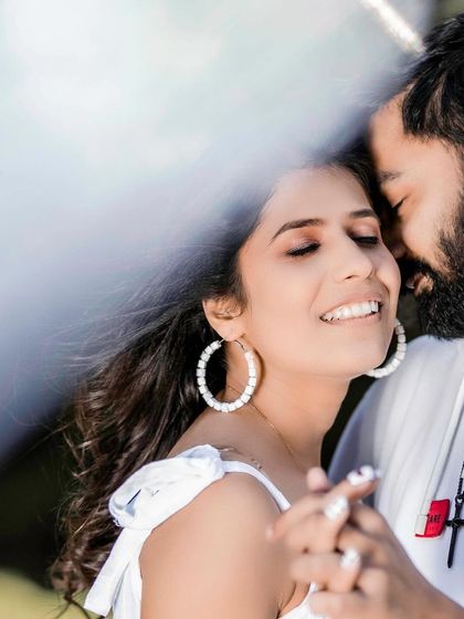 A beautiful, soft-focus shot of the couple sharing an intimate moment. The bride's happy, relaxed expression shows the comfort and trust she feels in her partner's arms.