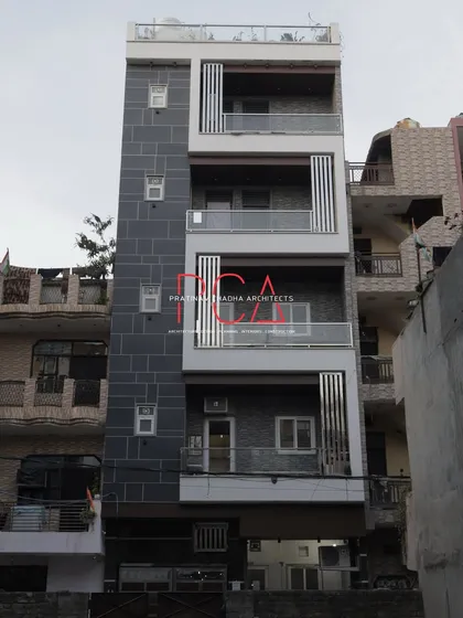 A daytime shot of 'The Cursive Abode', providing a clear view of the material details, including the stone texture and the sleek glass railings of the balconies.