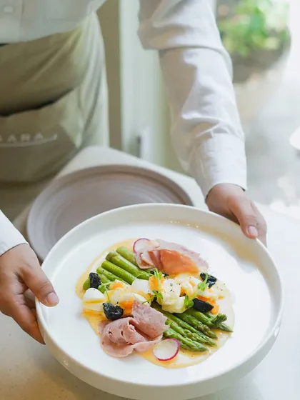 A celebration of local flavors. This dish features tender Himalayan asparagus from the Chamba region, paired with ham, crumbled egg, and a light hollandaise sauce. A European classic made with Indian produce.