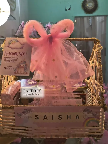 A close-up of one of the 80 finished hampers. Each basket included a personalized "Thank You" card and a name tag, all matching the unicorn and rainbow theme of the first birthday party.