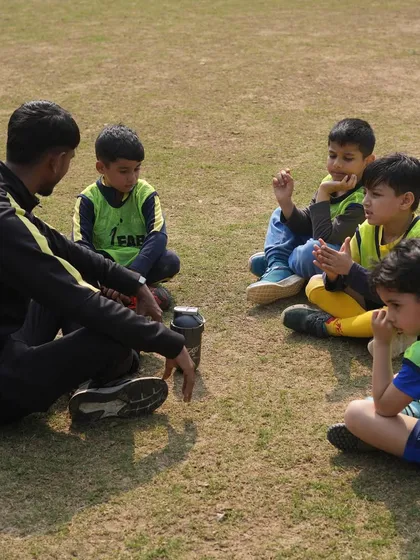 A coach sitting with his players. We impart wisdom, instill discipline, and nurture the potential within each player.
