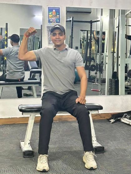 Seated bicep flex on a gym bench.