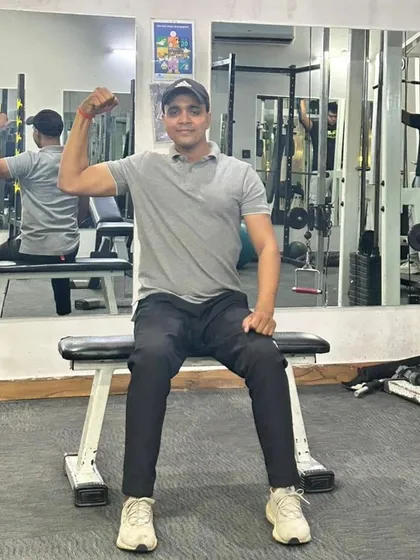 Seated bicep flex on a gym bench.