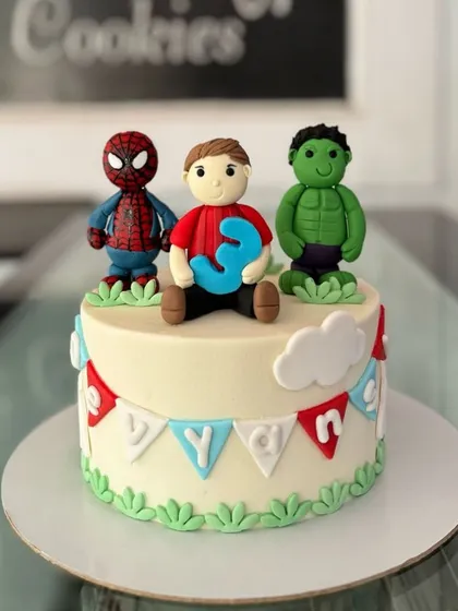 A superhero celebration featuring handcrafted fondant figures of Spider-Man and the Hulk. This custom cake is perfect for a young Marvel fan's third birthday.