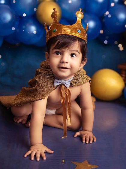 Every little boy is a prince in his mother's eyes. Here, he's dressed for a royal celebration, complete with a crown and cape, ready for his milestone portrait.