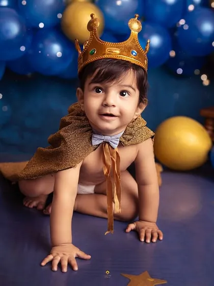 Every little boy is a prince in his mother's eyes. Here, he's dressed for a royal celebration, complete with a crown and cape, ready for his milestone portrait.