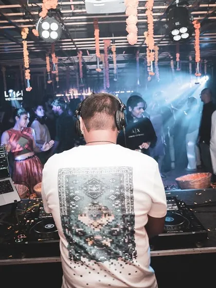 A view from behind the decks during a festive event, with traditional marigold decorations adding to the celebratory atmosphere.