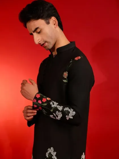 A model adjusting the cuff, showing the detailed embroidery that continues onto the sleeves.