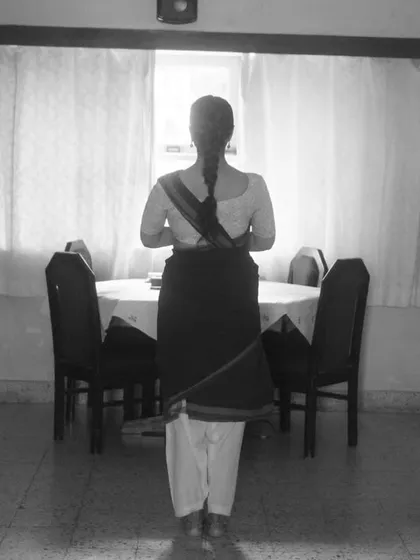 A quiet, silhouetted portrait of the dancer against the window, creating a sense of peace and anticipation before her practice.