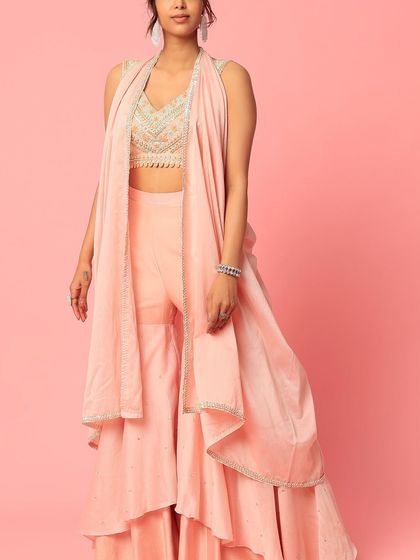 A story in every stitch. This peach sharara set with a layered design and an embroidered top is a beautiful example of custom ethnic wear.