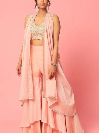 A story in every stitch. This peach sharara set with a layered design and an embroidered top is a beautiful example of custom ethnic wear.