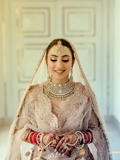 A beautiful portrait of a Sikh bride, her serene expression capturing the peaceful moments before the ceremony. Her pastel lehenga and intricate jewelry are highlighted perfectly.