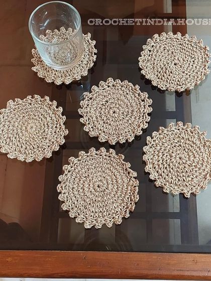 A set of six crochet coasters made with a natural, jute-colored yarn, offering a simple and earthy aesthetic for your home.
