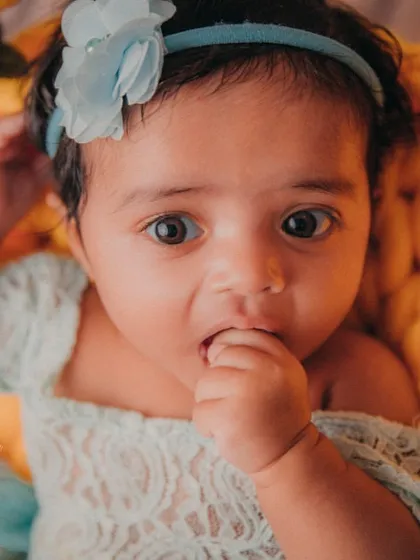 A tiny hand to the mouth is one of the cutest baby poses. This 3-month-old girl was a natural in front of the camera.