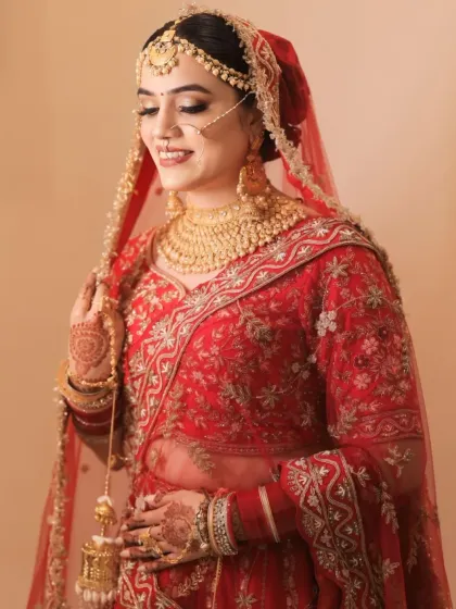 A beautiful candid shot. The golden jewelry and the warm tones in her makeup create a harmonious and traditional bridal look.