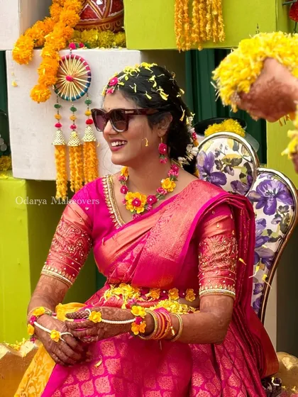 The bride's swag is on full display. The combination of a traditional South Indian saree and modern sunglasses for her Haldi is the perfect blend of tradition and fun.