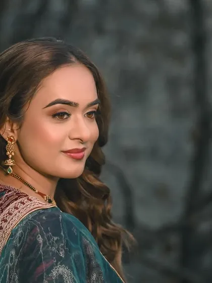 A beautiful portrait of the bride from her engagement or sangeet, set against a moody, natural backdrop.