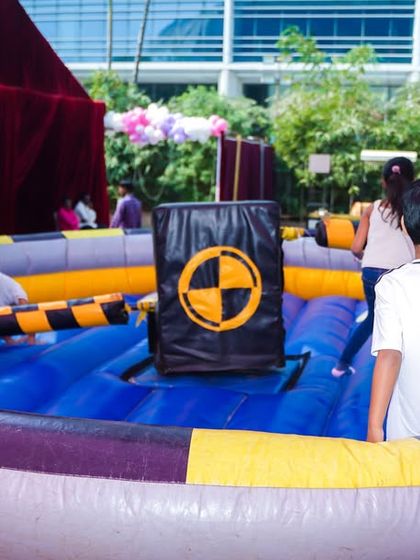 The inflatable mechanical wipeout game in action, a thrilling attraction for older kids and adults at the party.