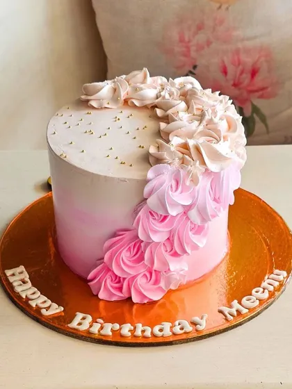 A simple yet beautiful cake with a cascade of pink ombre buttercream ruffles and a sprinkle of gold dust.
