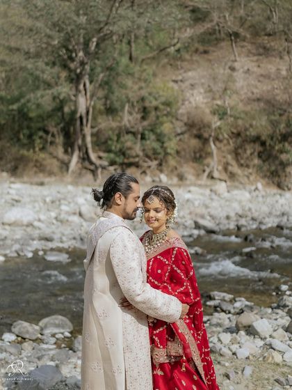 An intimate portrait of the bride and groom by the river in Rishikesh. The natural landscape provides a stunning, serene backdrop for this post-wedding couple shoot.