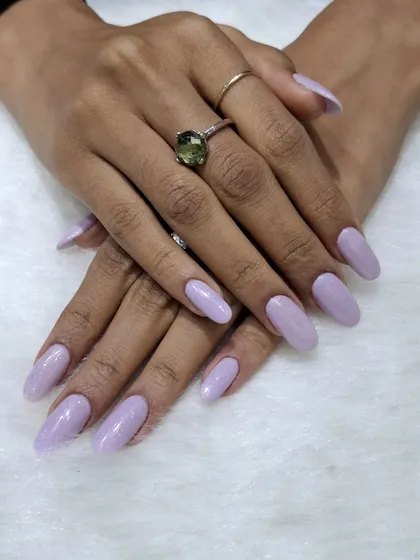 A simple and serene look featuring a solid soft lavender color on medium-length almond nails. This pastel shade is chic, calming, and effortlessly stylish.