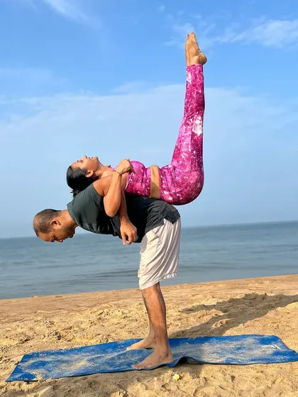 Reaching for the sky together in this standing acro-yoga pose. This lift requires a strong base and a light flyer, embodying the five elements of nature: earth, water, fire, air, and space.
