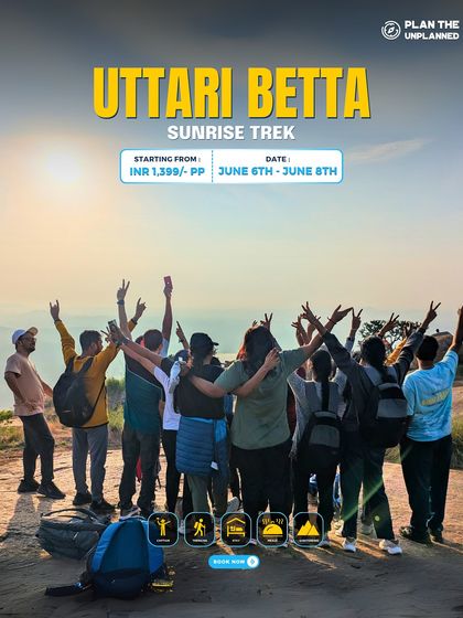 A group celebrates at the top of Uttari Betta, having completed the sunrise trek.