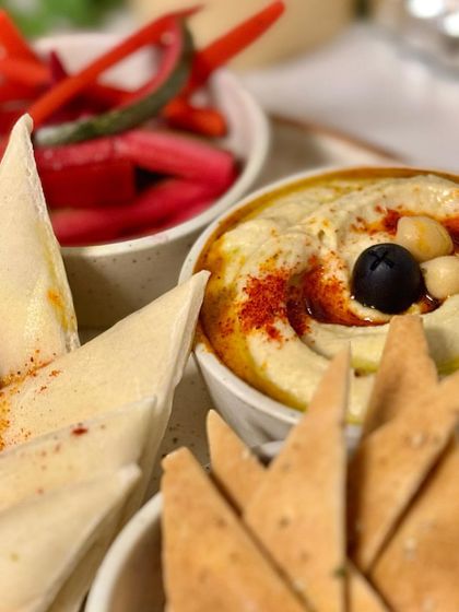 Our classic mezze platter featuring creamy hummus, pita bread, and pickled vegetables. A taste of the Mediterranean, perfect for any gathering.