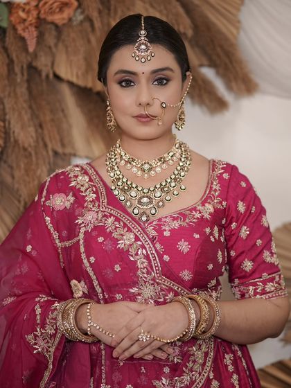 A complete bridal look featuring a heavy, gold-plated Kundan necklace, haath phool, and maang tikka, all available for rent.