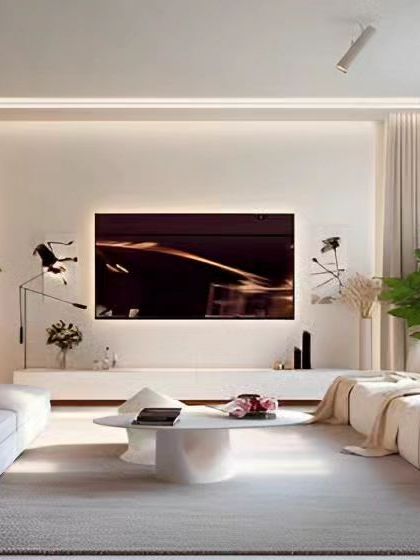 A bright and airy living room with a minimalist aesthetic. The all-white design is accented with lush green plants, creating a calm and refreshing space centered around a sleek, low-profile TV unit.