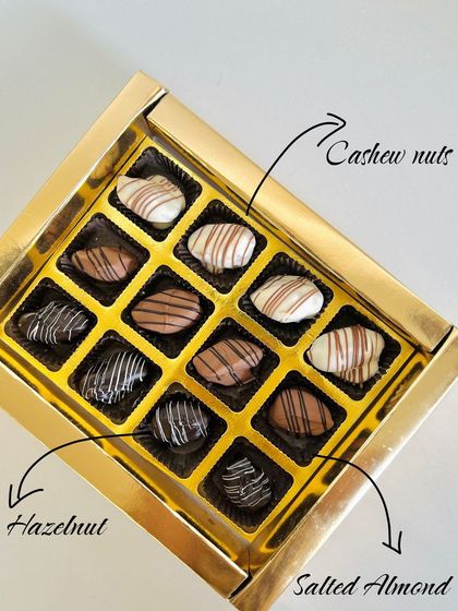 A box of my handcrafted chocolates, featuring flavors like cashew nut, hazelnut, and salted almond, each with a unique design.