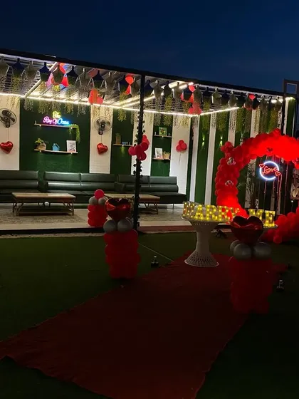 A wide shot of the full rooftop area decorated for a proposal. You can see the main "MARRY ME" arch as well as heart-shaped balloons and other touches I added to the lounge area.