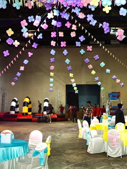 The full view of the Candyland party hall, with colorful ceiling decorations, themed tables, and multiple activity zones.