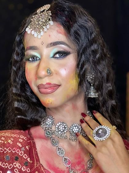 A close-up of a beautiful Holi-inspired look, with smudges of color on a full glam base.