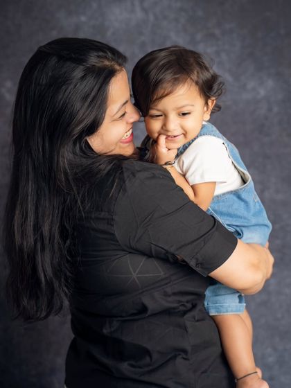 A sweet, candid moment between a mother and her child. The baby's gentle touch on his mom's face is a small detail that makes the photo priceless.