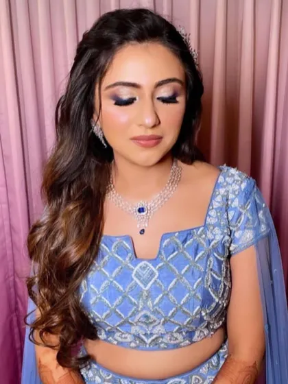 A half-updo with a twisted braid and soft curls for a sangeet.