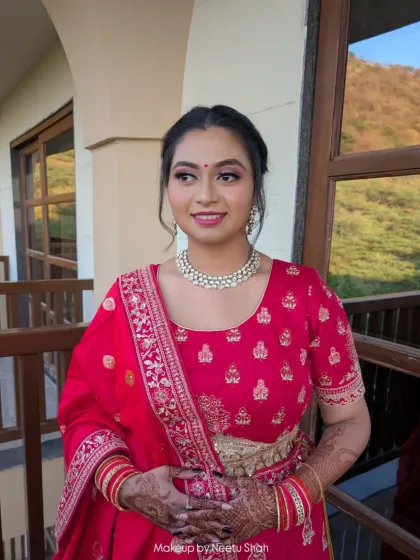 A smiling portrait showing a fresh and happy party makeup look. The outdoor lighting highlights her glowing skin and natural beauty.