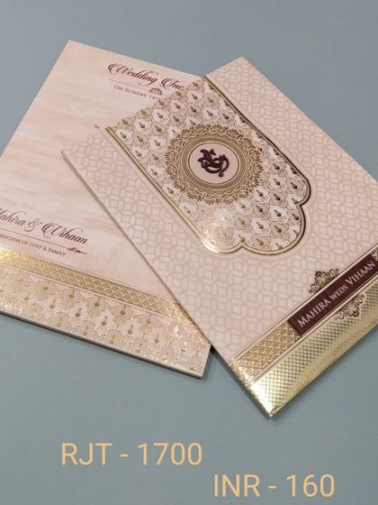 This invitation features a beautiful Ganesha emblem at the center of an intricate mandala design. The card uses classic gold foil on a cream background for a timeless look.