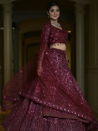 A full-length view of our wine-colored sequin lehenga. The rich color and all-over sparkle make it a glamorous and sophisticated choice for an evening reception or cocktail party.