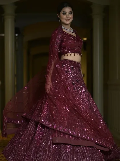A full-length view of our wine-colored sequin lehenga. The rich color and all-over sparkle make it a glamorous and sophisticated choice for an evening reception or cocktail party.