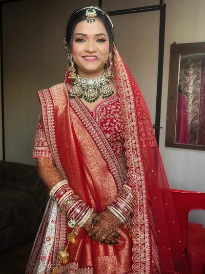 A beautiful portrait of the bride ready for her pheras. The makeup highlights her features with a soft glow, perfectly matching her red and white lehenga.